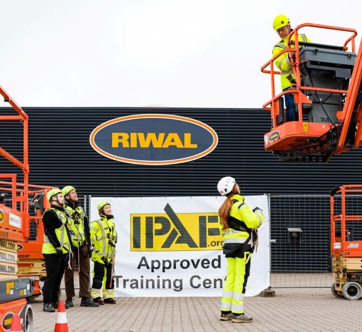 Operario con arnés utilizando una plataforma elevadora
