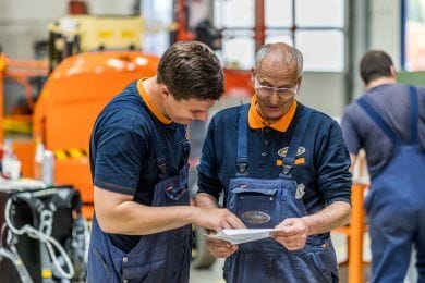 Riwal monteurs overleggen met een JLG Riwal hoogwerker achter hun